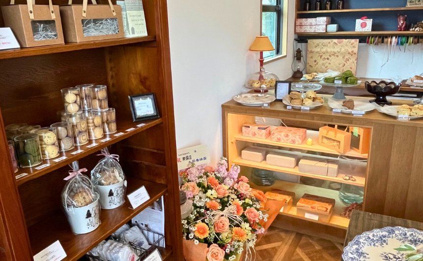 ショーケースに美しく並べられた色とりどりのショートケーキなどの生菓子と、横に並ぶ種類豊富な焼き立てスコーンの写真。お店の看板商品であることが伝わる魅力的なアングルで