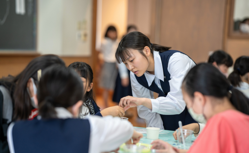 制服姿の在校生が小学生に寄り添って丁寧にサポートしている様子