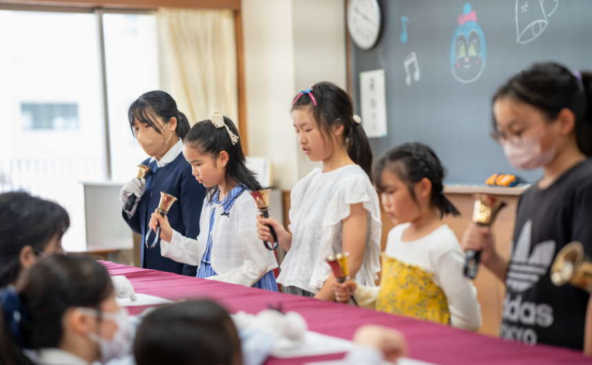 在校生と小学生が一緒にハンドベルを演奏している様子